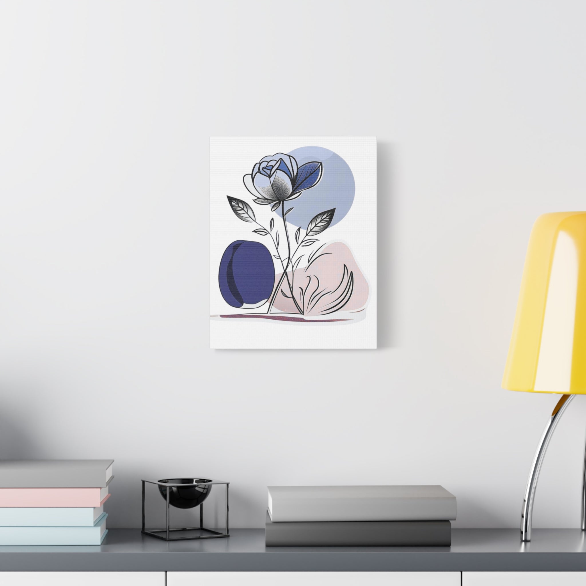 Abstract floral artwork on a wall above a desk with books and a lamp.