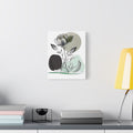 Framed artwork of a rose on a wall above a desk with books and a lamp.