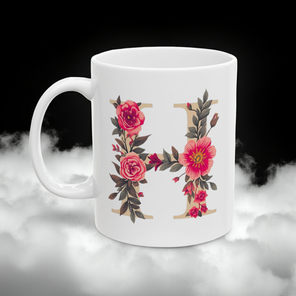White mug with floral letter 'H' design on a dark background
