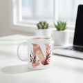 Mug with floral letter 'N' design on a desk with a laptop and plants