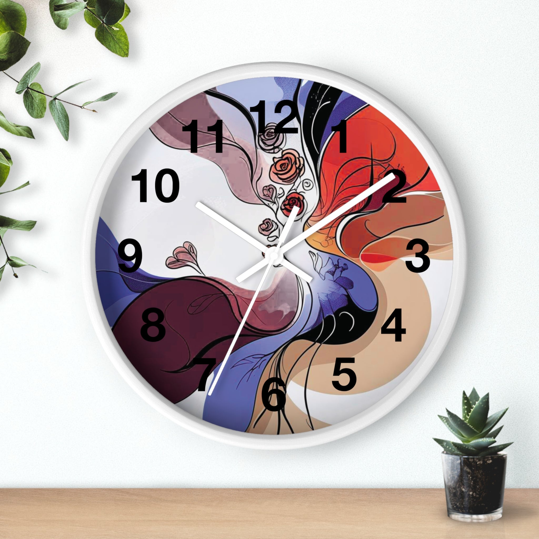 Colorful abstract wall clock on a white background with a plant and small pot.