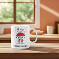 White mug with a red umbrella design and text on a wooden surface.