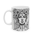 White mug with black and white artistic design of a woman's face and floral elements on a white background